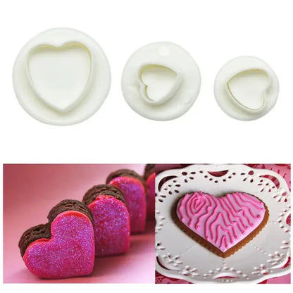 Set of three white heart shaped cake decorating cookie cutters with examples on decorated cookies and chocolate hearts