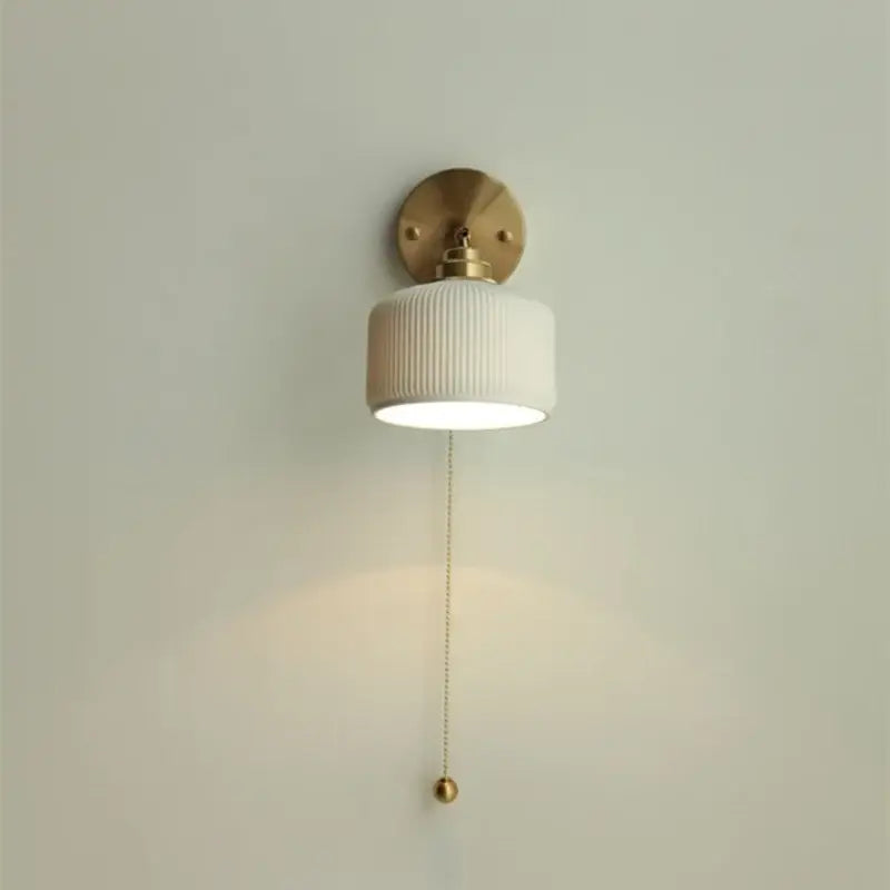 White ribbed ceramic led wall sconce with brass mount and pull chain for bedroom lighting by decorbites ceramic led
