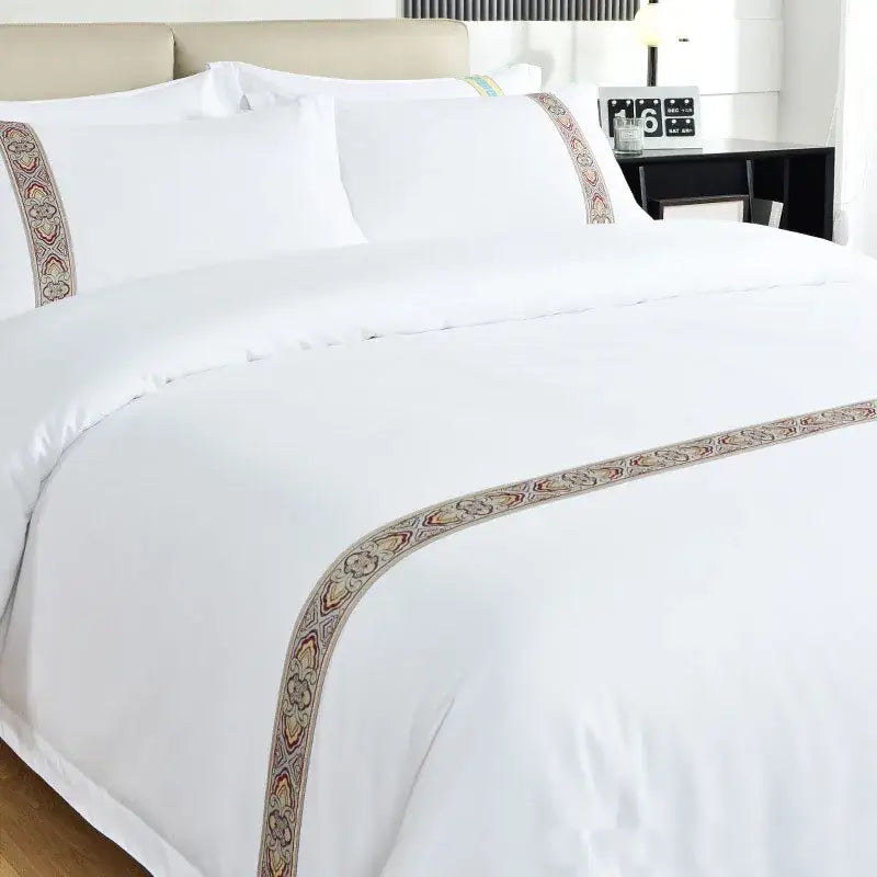 White satin bedding set with cozy solid color white bedspread featuring an embroidered paisley border in beige red and gold