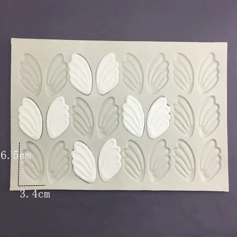 White silicone cake mold with leaf-shaped cavities arranged in three rows ideal for swan neck decorbites 3d wings design