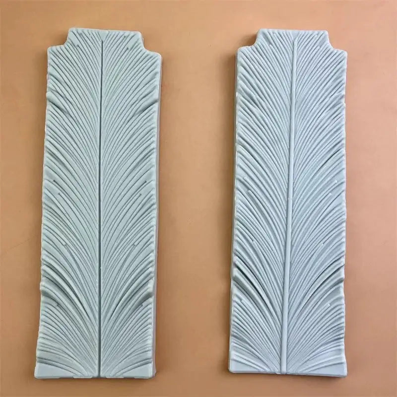 Two light blue ceramic tiles with detailed feather-like relief pattern for white silicone 3d wings cake mold swan neck decorbites 3d wings