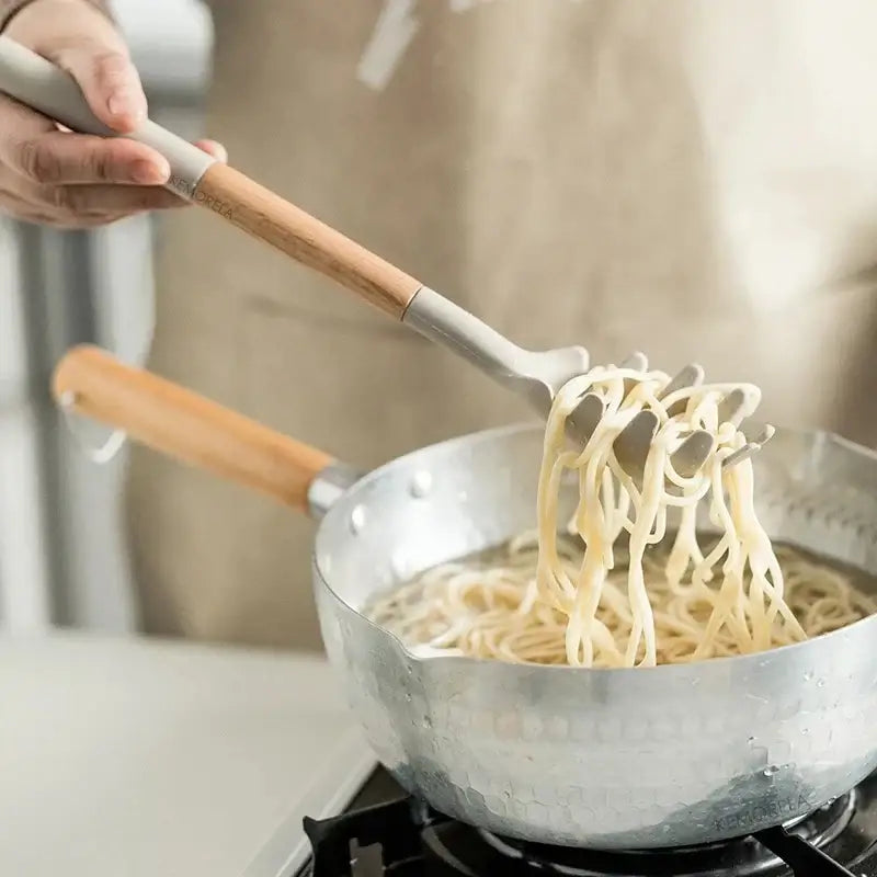 Silver pasta server with wooden handles from white silicone kitchen cookware set with wooden handles and holder