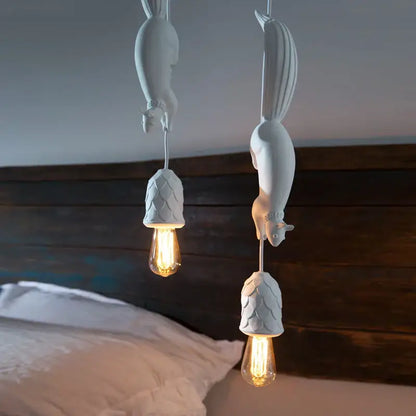 White squirrel pendant light with textured shell-like shades and exposed filament bulbs as a decorative focal point