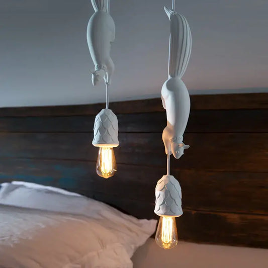 White squirrel pendant light with textured shell-like shades and exposed filament bulbs as a decorative focal point