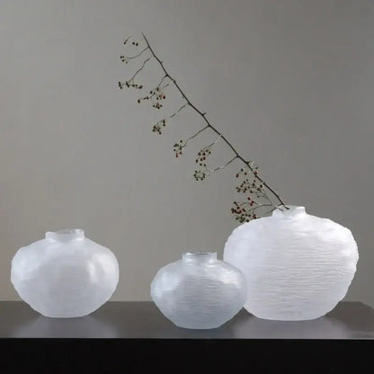Three translucent white glass pleats vases with textured rounded surfaces and narrow necks for living room decor