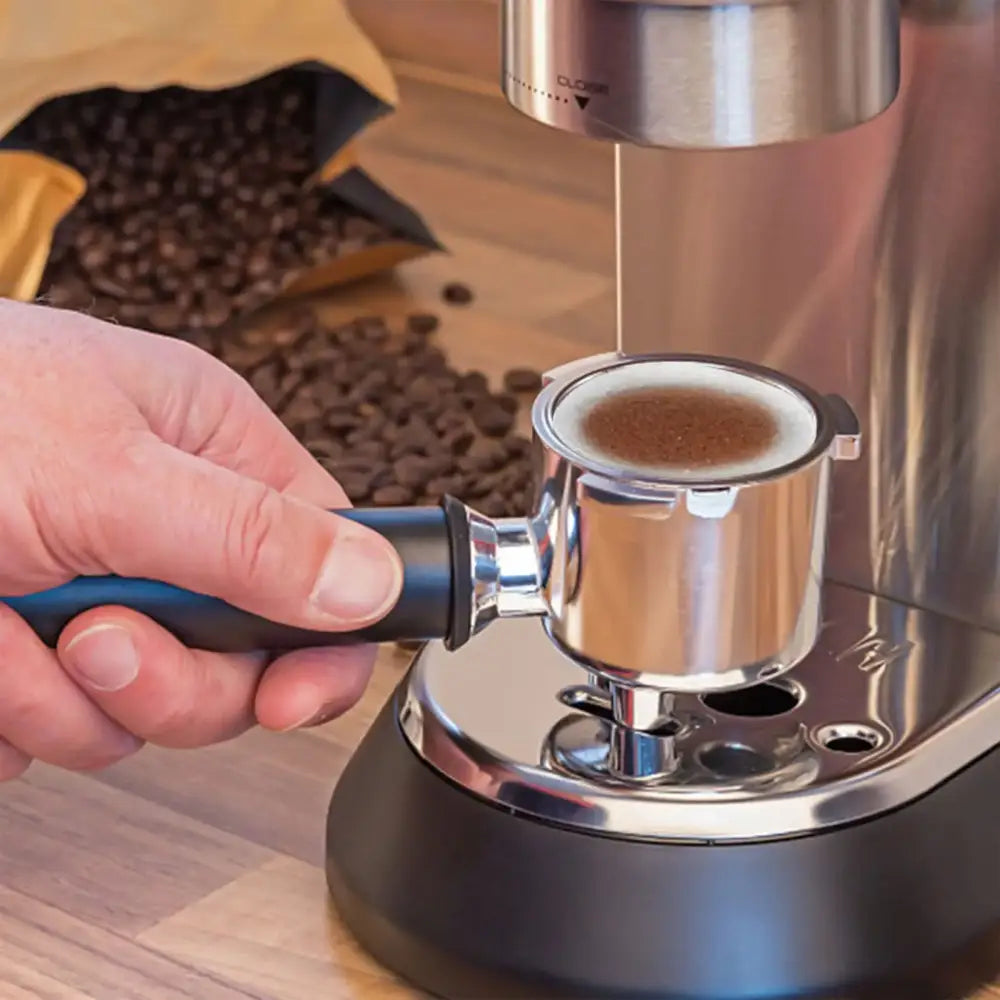 A sleek stainless steel espresso machine with black base and blue handle brewing rich coffee in decorbites espresso portafilter special powder filter