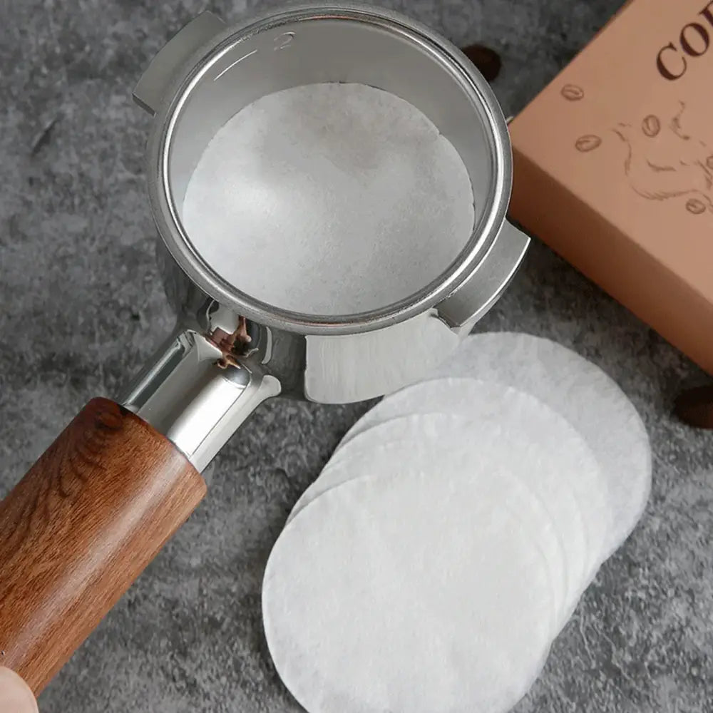 White textured espresso portafilter with wooden handle holding decorbites espresso portafilter special powder filters