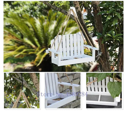 White plastic bird feeder chair designed as miniature adirondack chair suspended by natural fiber ropes