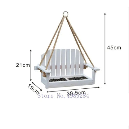White wooden adirondack bird feeder chair with rope suspension and slatted design for garden decor