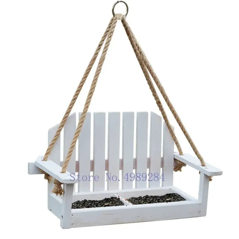 White wooden adirondack bird feeder chair with rope suspension and divided seed compartments for garden decor