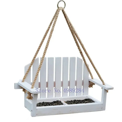 White wooden adirondack bird feeder chair with rope suspension and divided seed compartments for garden decor