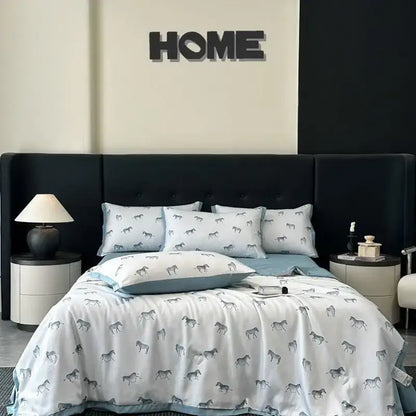 White zebra print cool silk summer quilt set with gray zebras paired with matching pillowcases and light blue bed skirt
