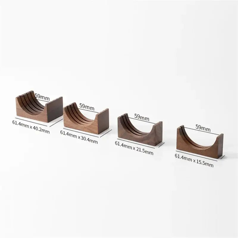 Set of four dark brown wooden espresso filter screen holders with grooved interiors and gray coasters kitchen stand