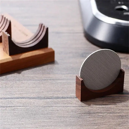 Gray textured circular coaster resting in dark wood wooden filter screen holder for espresso kitchen use
