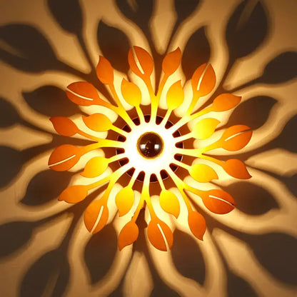 A warm glowing wooden floral sunburst wall lamp with orange and yellow leaf-shaped panels for bedroom lighting