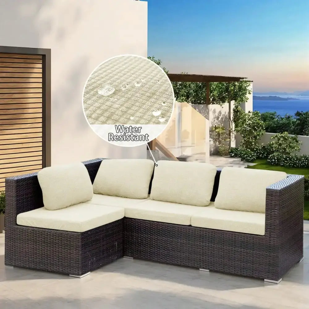 Dark brown woven wicker modular sofa with cream-colored cushions featuring outdoor sectional protection cover