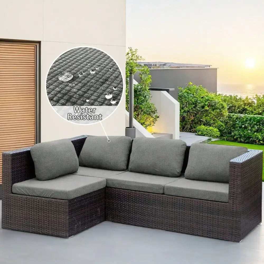 Dark brown woven wicker l-shaped modular sofa with gray cushions featuring brown and cream outdoor protection cover