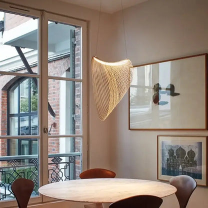 Warm golden woven nest led pendant light with sculptural curved design made of thin strands for dining room decorbites bird’s nest