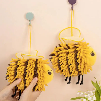 Yellow and black bee shape chenille hand towels in yellow and brown fuzzy design hanging from hooks for bathroom use