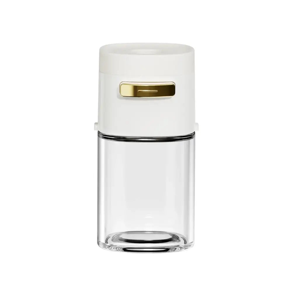 A sleek white and clear glass spice dispenser with a gold-tone lid handle for travel-sized kitchen use