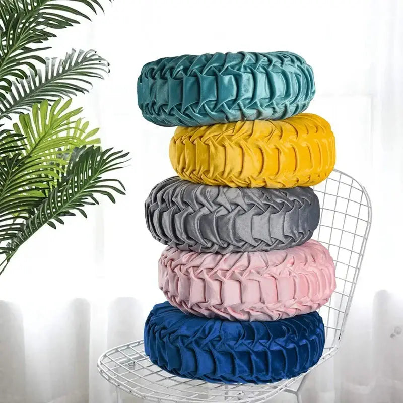 Stacked yellow pleated velvet throw pillow with teal pink gray and blue covers featuring textured decorbites 3d pumpkin design