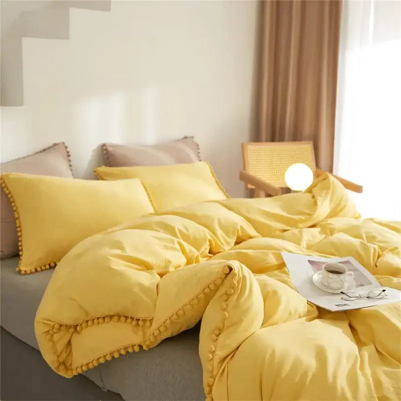 Yellow quilted furball tasseles bedding set featuring a yellow pom pom trimmed duvet cover for cozy decorbites furball tasseles decor
