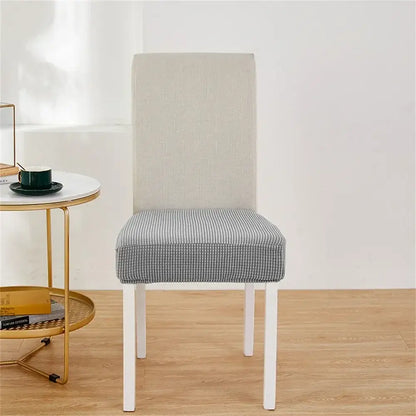 Modern dining chair with white frame and checkered seat featuring a yellow ribbed fleece chair cover for protection