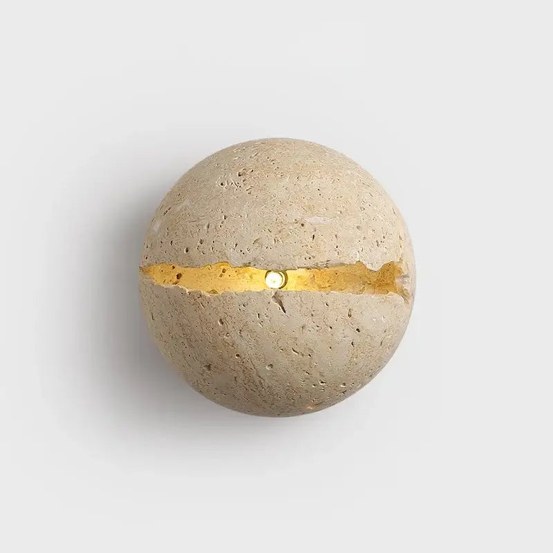 A spherical yellow travertine dino egg stone wall lamp with beige textured surface and gold accent for decorbites dino egg
