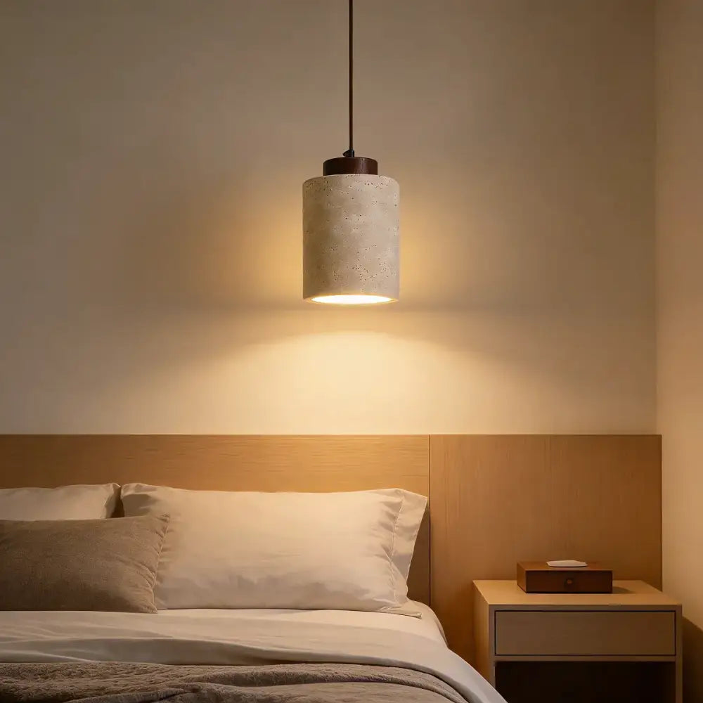 Yellow travertine stone pendant light with concrete cylinder and dark metal fixture for kitchen lighting