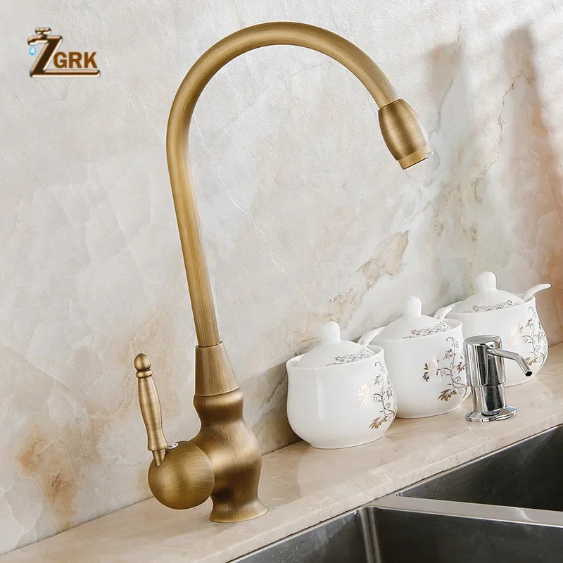 Antique brass deck mounted single hole kitchen faucet with curved spout and ornate handle for vessel sink